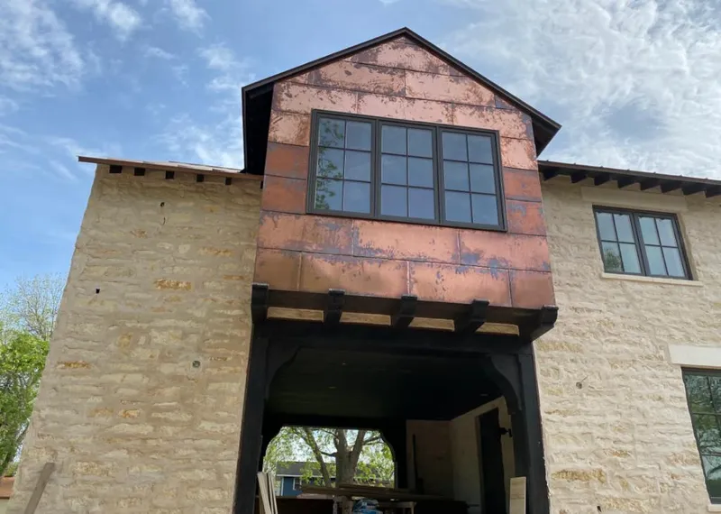 Copper metal panel facade on a stone building for Skylight Installation in Finley